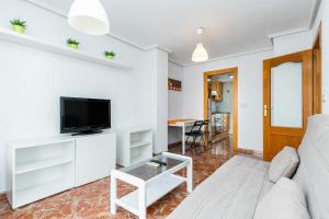 a living room with a white couch and a tv at Sunrise Arts 1 in Torrevieja