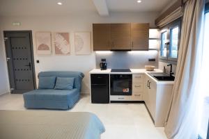 a small kitchen with a blue chair and a table at Themelina Studios in Emborios