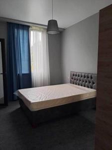 a large bed in a room with a large window at Mari's Villa in Batumi