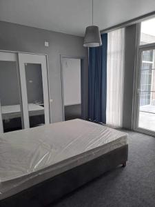 a bedroom with a bed and a large window at Mari's Villa in Batumi