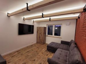 a living room with a couch and a flat screen tv at BLUE Reset in Ruciane-Nida