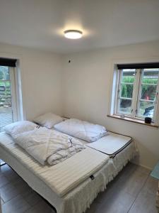a large bed in a room with two windows at Marku House 2-plans huse in Struer +7 photos