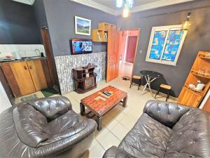 a living room with a leather couch and a table at The Yafé Bastos 6 in Yaoundé