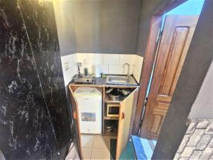 a small kitchen with a sink and a stove at The Yafé Bastos 6 in Yaoundé
