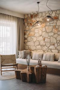 a living room with a couch and a stone wall at Bedrock beachside villa with private pool in Vasilikos