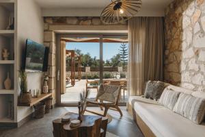 a living room with a couch and a table at Bedrock beachside villa with private pool in Vasilikos