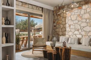 a living room with a stone wall at Bedrock beachside villa with private pool in Vasilikos