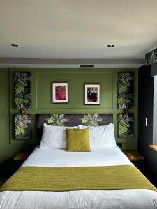 a bedroom with a large bed with green walls at The Baltic Hotel in Liverpool