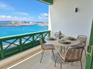 a table and chairs on a balcony with a view of the ocean at Casa Balcón del Puerto in Playa Blanca