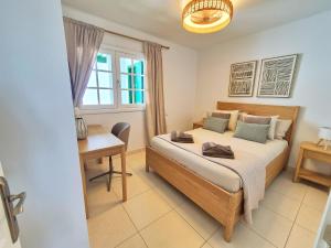 a bedroom with a bed and a desk and a window at Casa Balcón del Puerto in Playa Blanca