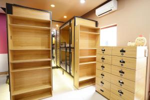a walk in closet with wooden shelves and wooden cabinets at Saigon Box Hostel in Ho Chi Minh City