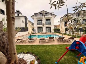 a house with a swimming pool in a yard at As Villas Villa Asil in Fethiye