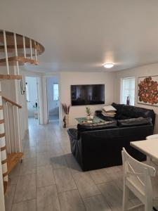 a living room with a black couch and a table at Marku House 2-plans huse in Struer