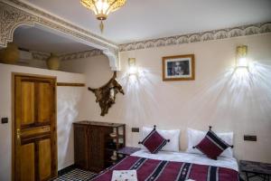 a bedroom with a bed and a chandelier at Dar al haja rahma in Fez