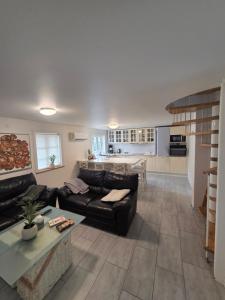 a living room with a couch and a kitchen at Marku House 2-plans huse in Struer