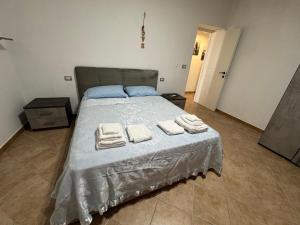 a bedroom with a bed with towels on it at Casa via veneto in Carbonia