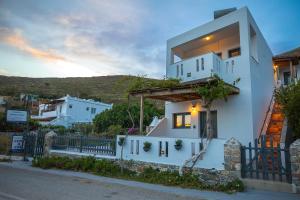 a white house with a sunset in the background at Themelina Studios in Emborios