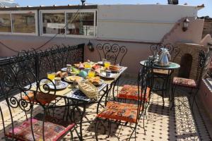 a table and chairs with food on a balcony at Dar al haja rahma in Fez