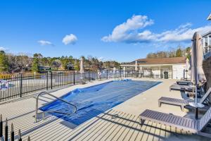 a swimming pool on a deck with two benches at Pool & Lake Access! Sherrills Ford Tiny Home in Sherrills Ford