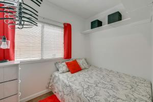a bedroom with a bed with a red window at Pool & Lake Access! Sherrills Ford Tiny Home in Sherrills Ford +21 photos