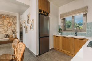 a kitchen with a refrigerator and a table and chairs at Bedrock beachside villa with private pool in Vasilikos +41 photos