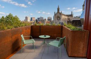 a balcony with two chairs and a table and a city at BX Downtown - Brussels in Brussels