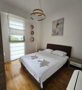a bedroom with a bed with white sheets and a window at Harmonia Budva 1 in Budva