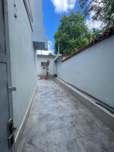 an alley with a white wall and a door at Flag's Square House Vlore in Vlorë