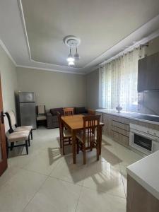 a kitchen and living room with a table and chairs at Flag's Square House Vlore in Vlorë +2 photos