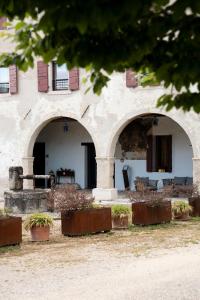 a building with arches and plants in front of it at Tenuta Malvolti - Al Vecchio Convento in San Fior di Sopra