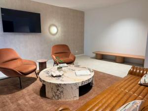 a waiting room with two chairs and a coffee table at Lumi Residence Robina in Gold Coast