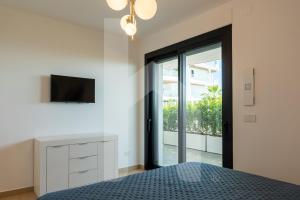 a bedroom with a bed and a tv on a wall at Homiday - WaterFront Roseto in Roseto degli Abruzzi