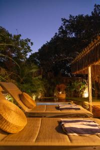 a group of lounging chairs on a deck with a resort at AWÊ Villa Boutique & Beach Club in Trancoso