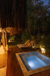 a swimming pool in the middle of a yard at night at AWÊ Villa Boutique & Beach Club in Trancoso +69 photos