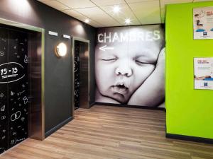 a hallway with a large poster of a woman with her eyelashes at ibis budget Belfast City Centre in Belfast