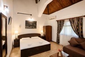 a bedroom with a large bed and a couch at Serenity Lake Front Villa in Moratuwa +48 photos