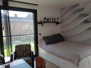 ein kleines Schlafzimmer mit einem Bett und einem Fenster in der Unterkunft Recup in Beernem