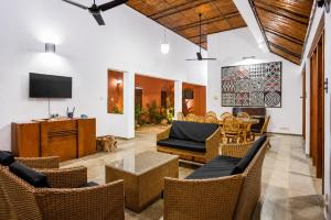 a living room with wicker furniture and a tv at Serenity Lake Front Villa in Moratuwa