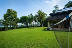 a large yard with a net in front of a house at Serenity Lake Front Villa in Moratuwa