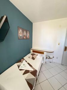 a room with two beds and a desk in it at Big Hotel Florianópolis in Florianópolis