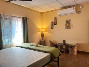 a bedroom with a bed and a window and a fan at Mulaqat Homestay in Siliguri
