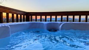 a jacuzzi tub on the deck of a house at FireFly Acres in Sparta