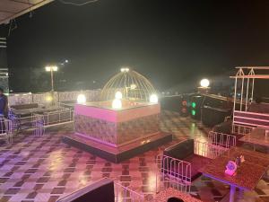 a room with tables and chairs on a balcony at night at Hotel NDH 47 in Korādih +7 photos