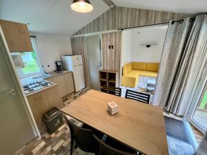 a kitchen and dining room with a table in a room at Camping le Martin Pêcheur in Magné +15 photos