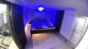 a purple bedroom with a bed in a room at The Yafé Bastos 9 in Yaoundé