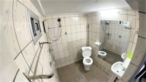a bathroom with a toilet and a sink at The Yafé Bastos 9 in Yaoundé +7 photos