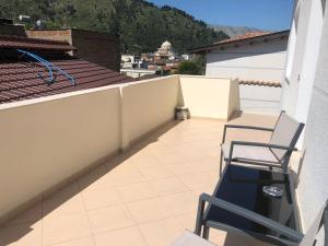 a balcony with two chairs on a roof at House of Leaves in Berat
