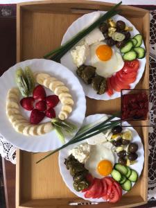 two plates of breakfast food on a wooden tray at House of Leaves in Berat