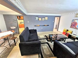 a living room with two couches and a table at The Yafé Bastos 9 in Yaoundé