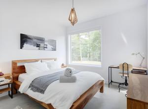 a bedroom with a large bed with white sheets and a window at Modern Luxury Chalet Private Jacuzzi in La Conception +15 photos